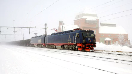HD PC desktop wallpaper showing a black and red train moving on snowy tracks with industrial buildings in the background.