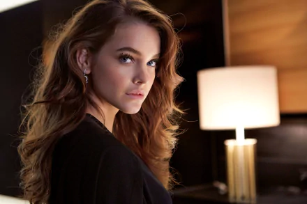 HD desktop wallpaper of Hungarian celebrity model Barbara Palvin with blue eyes and brunette hair, posing indoors beside a softly lit lamp.