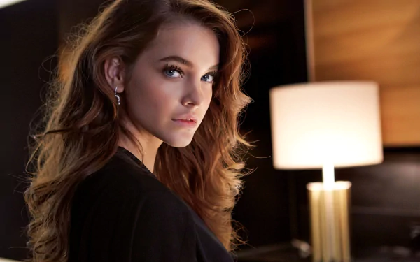 HD desktop wallpaper of Hungarian celebrity model Barbara Palvin with blue eyes and brunette hair, posing indoors beside a softly lit lamp.