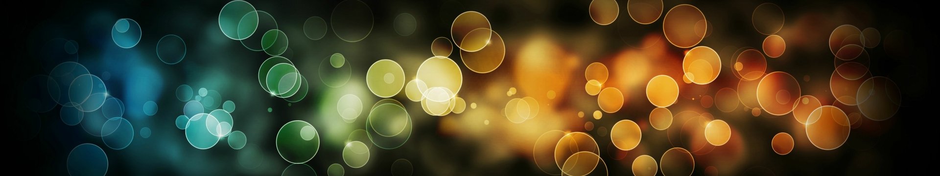 Artistic bokeh HD PC desktop wallpaper: soft green and amber light orbs drifting over a dark, blurred background.