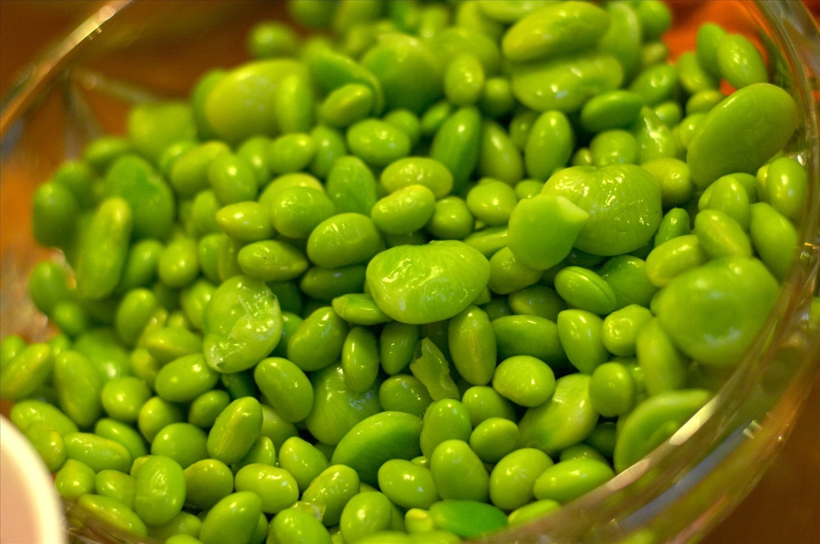 HD PC desktop wallpaper of glossy bright green lima beans piled in a bowl.