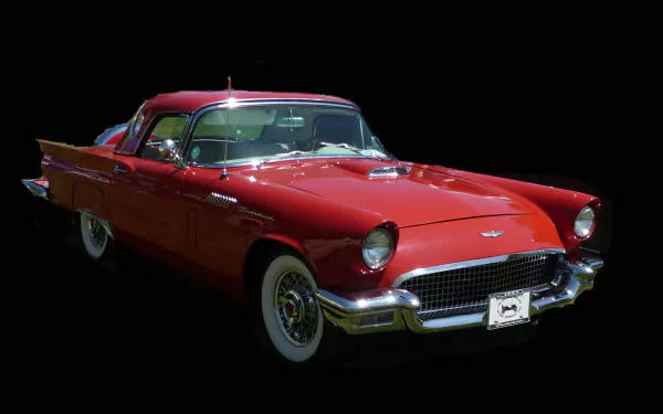 Red classic Ford Thunderbird coupe on a black background — 2K Quad HD PC desktop wallpaper showcasing the vintage Ford vehicle's sleek lines.