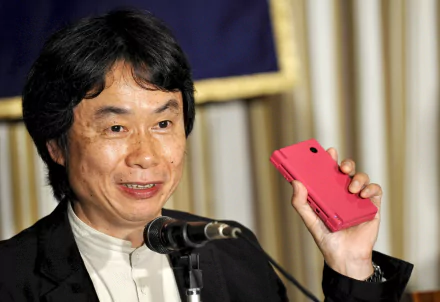 HD desktop wallpaper featuring a smiling person holding a red handheld device, set against an elegant background.