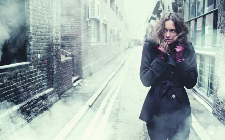 HD PC desktop wallpaper featuring a woman model in jeans and a black coat standing in a misty urban alleyway with a moody, atmospheric vibe.