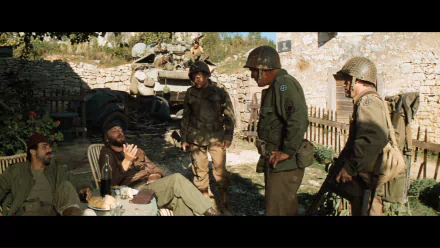 HD PC desktop wallpaper of the movie Kelly's Heroes: World War II soldiers in helmets and uniforms gathered and talking in a sunlit village courtyard.