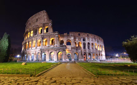 A stunning HD desktop wallpaper featuring the Colosseum illuminated at night, showcasing its majestic architecture amidst a tranquil setting.
