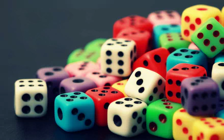 HD desktop wallpaper featuring a vibrant collection of colorful dice, artistically arranged on a dark background.