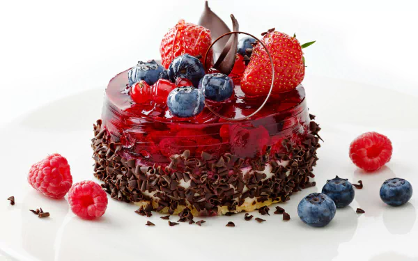 A delectable dessert featuring a glossy gelatin layer topped with fresh strawberries, blueberries, and chocolate shavings, designed as a high-definition PC desktop wallpaper.