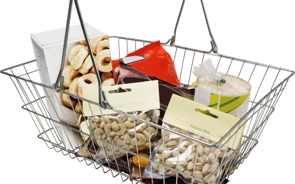 4K Ultra HD PC desktop wallpaper showing a metal shopping basket filled with packaged snacks, nuts and cookies on a white background — food, meal.