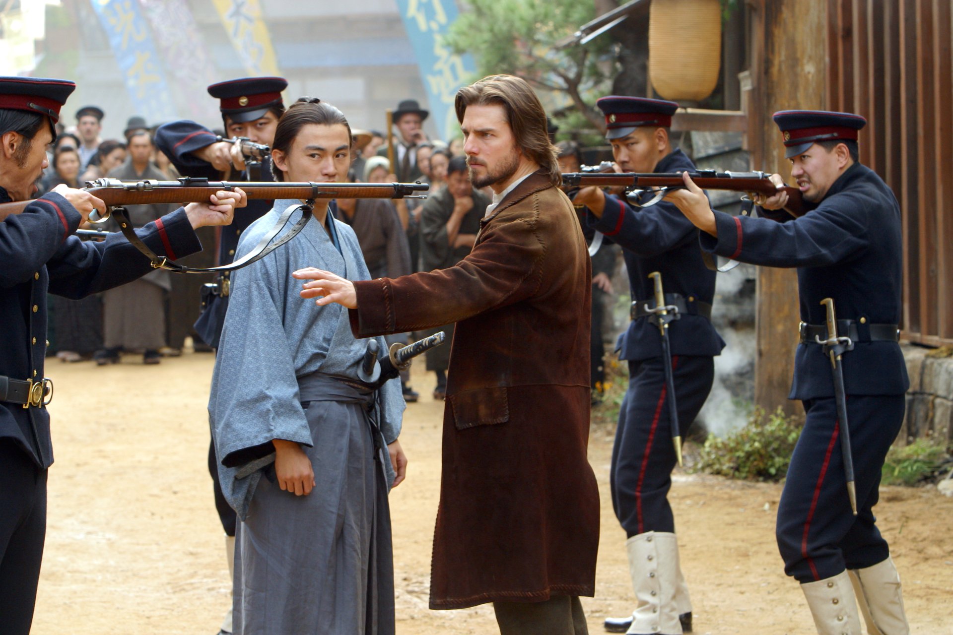 A dramatic scene from The Last Samurai, featuring intense standoffs between armed soldiers and samurai, set against a historical backdrop. High-definition wallpaper captures the tension.