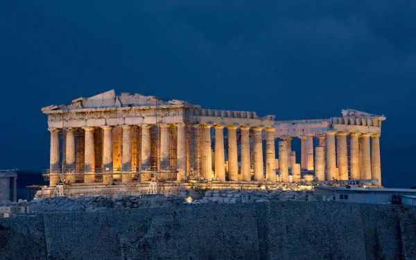 A stunning HD wallpaper of the Parthenon, showcasing its iconic columns illuminated against a dark sky, highlighting this remarkable man-made marvel.