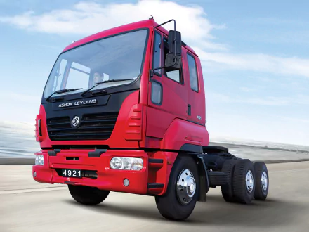 HD desktop wallpaper featuring a red Ashok Leyland heavy-duty truck against a clear sky background.