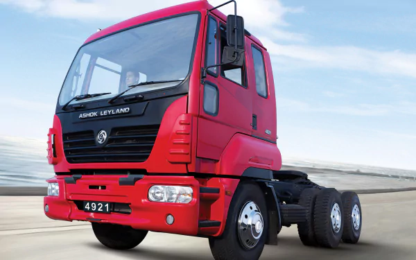 HD desktop wallpaper featuring a red Ashok Leyland heavy-duty truck against a clear sky background.