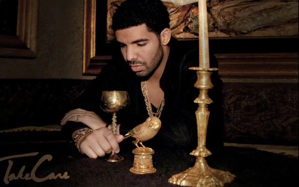 A high-definition desktop wallpaper featuring Drake, seated elegantly with a golden goblet and decorative candle holder, creating an atmospheric and artistic vibe.