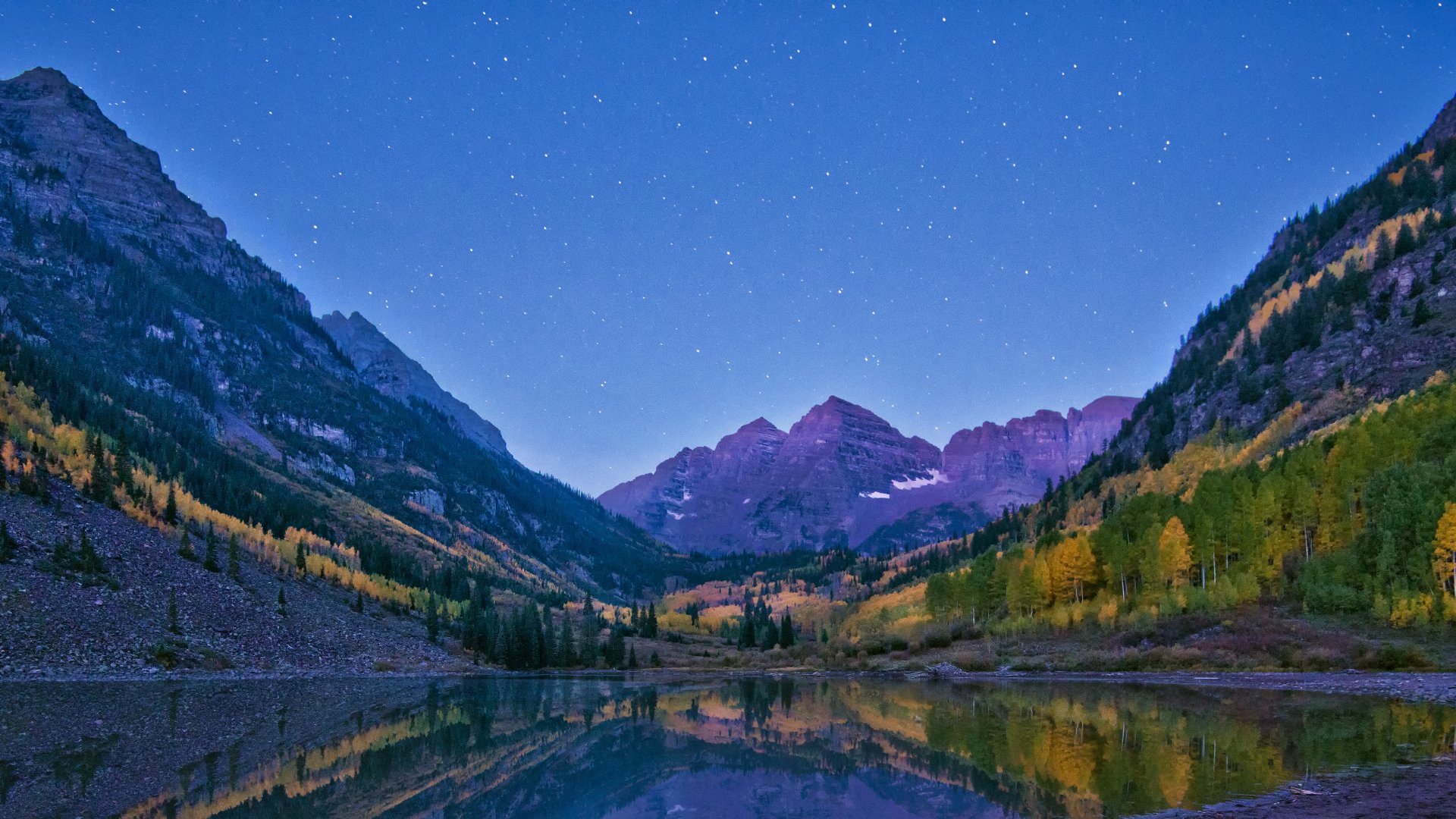 4K Ultra HD desktop wallpaper showcasing a serene mountain landscape at dusk, with starry skies and vibrant autumn foliage reflected in a calm lake.