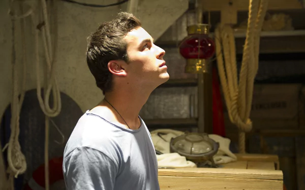 HD desktop wallpaper featuring celebrity Mario Casas in a softly lit room, looking upwards with a contemplative expression.