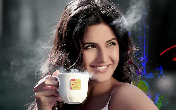 HD desktop wallpaper featuring Indian actress and celebrity Katrina Kaif, smiling while holding a steaming cup of tea.