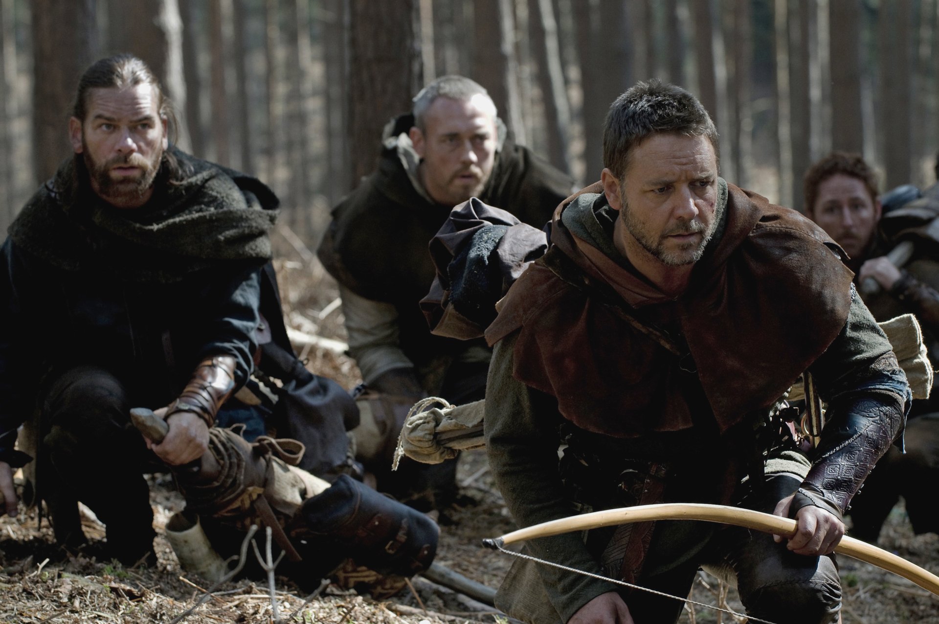 Russell Crowe in a tense forest scene from the 2010 Robin Hood movie, featured as an HD PC desktop wallpaper and background.
