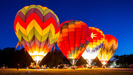 A vibrant scene featuring colorful hot air balloons illuminated against a night sky, creating a stunning HD desktop wallpaper and background.