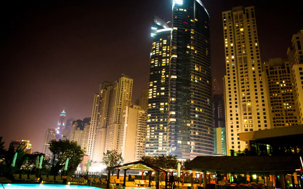 Night view of illuminated man-made skyscrapers in Dubai, captured in stunning 4K Ultra HD for a vibrant PC desktop wallpaper background.