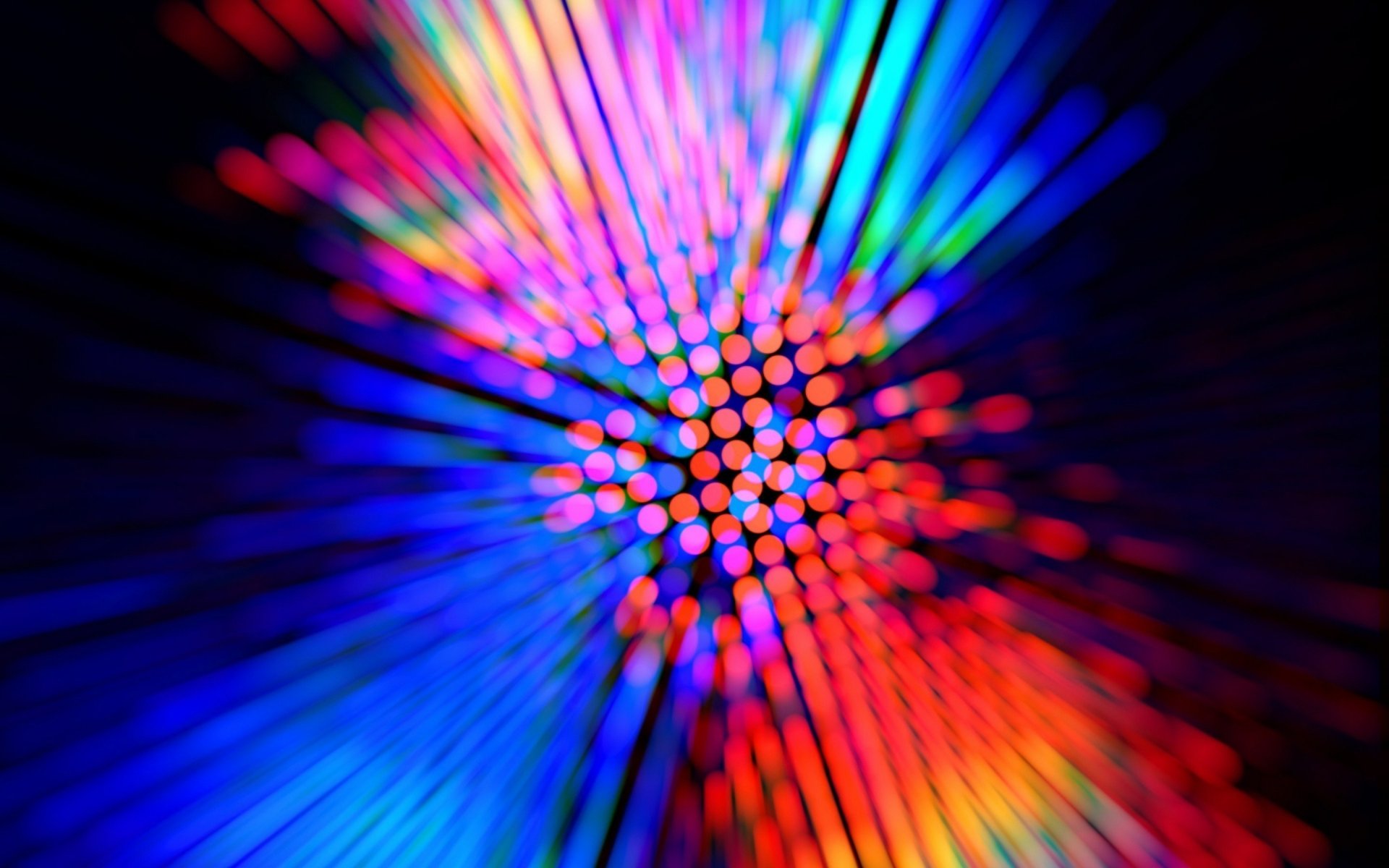 Abstract HD PC desktop wallpaper featuring a vibrant blur of multicolored lights radiating from the center against a dark background.