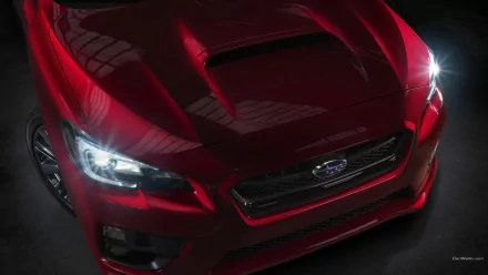 HD PC desktop wallpaper: red 2015 Subaru WRX front three-quarter view with headlights on and prominent hood scoop against a dark background.