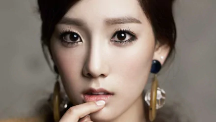 Close-up portrait of Kim Tae-yeon, Korean actress, dancer, TV presenter, and singer from Girls' Generation (SNSD), with striking eyes and elegant accessories.