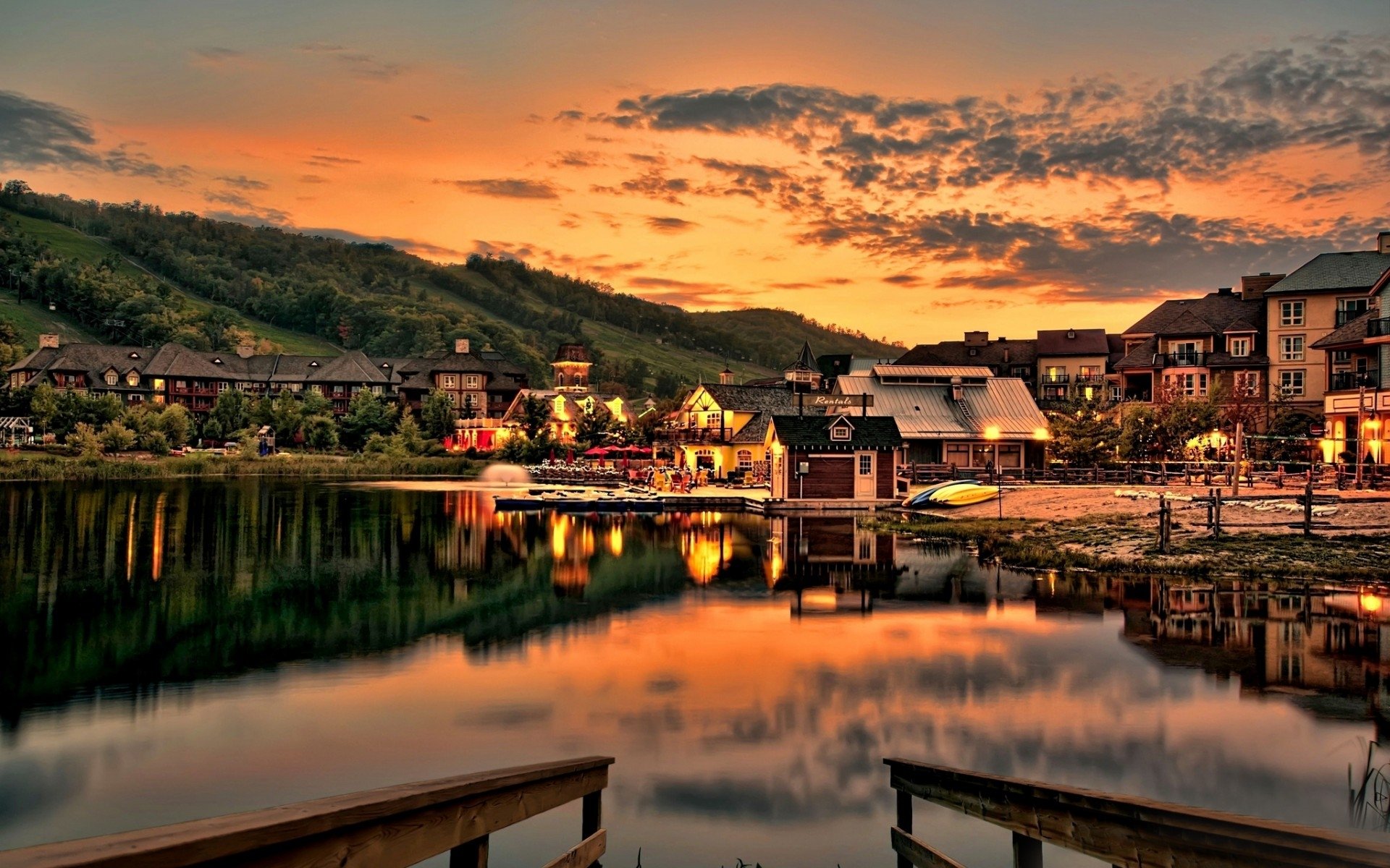 Man-made village at sunset with colorful sky reflected in calm water, captured in HD for a desktop wallpaper and background.