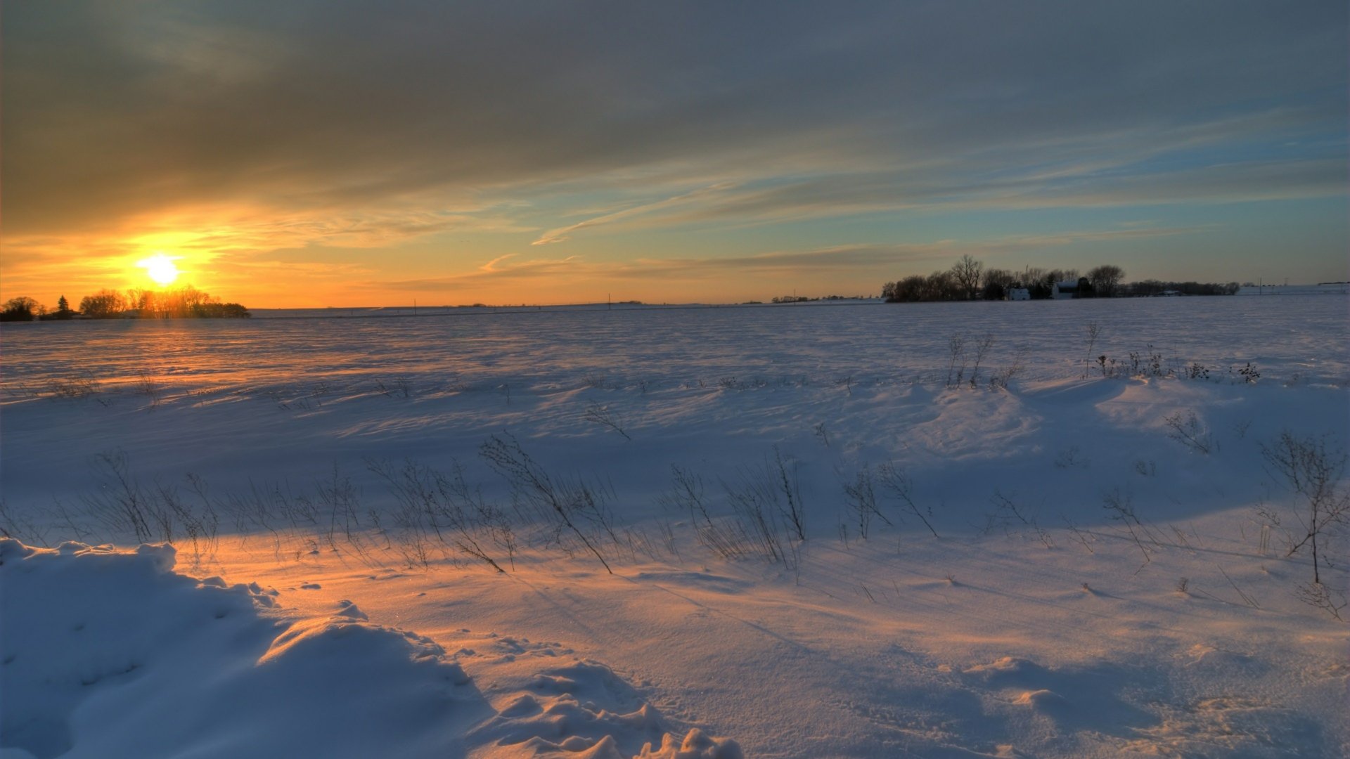 4K Ultra HD nature wallpaper showcasing a vibrant sunset over a snowy landscape with soft shadows and distant trees under a colorful sky.