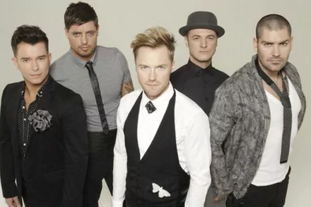 HD PC desktop wallpaper showing a five-member music boy band in coordinated smart-casual outfits, posed against a light neutral backdrop for a sleek music-themed desktop background.