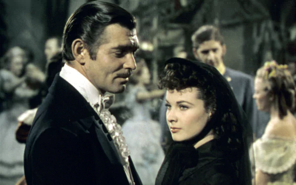 HD desktop wallpaper from the movie Gone With The Wind featuring Rhett Butler and Scarlett O’Hara in period costume during a social gathering.