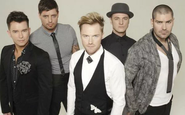 HD PC desktop wallpaper showing a five-member music boy band in coordinated smart-casual outfits, posed against a light neutral backdrop for a sleek music-themed desktop background.