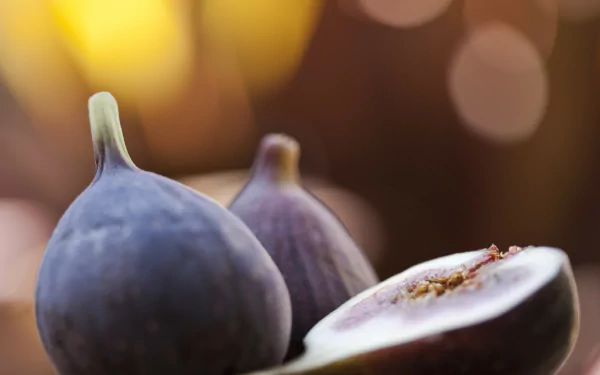 HD desktop wallpaper featuring a close-up of fresh figs with warm, blurred bokeh background highlighting the fruit’s texture and natural colors.