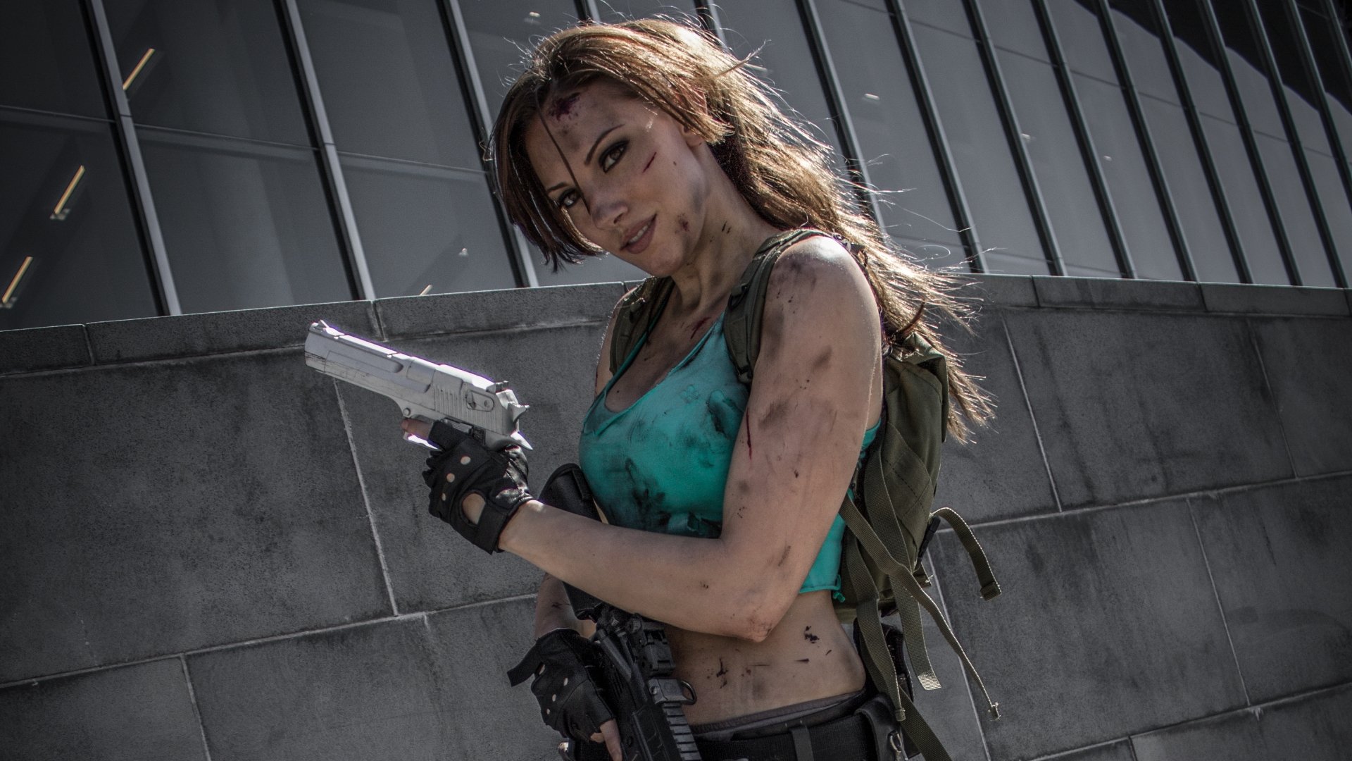 Lara Croft from Tomb Raider showcases an impressive cosplay in this HD desktop wallpaper, featuring a confident woman with a weapon, embodying the adventurous spirit of the character.