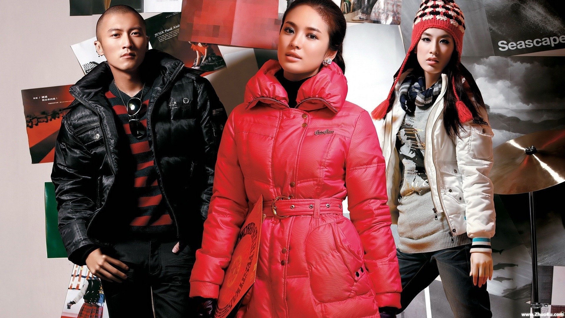 A stylish HD wallpaper featuring actress Song Hye-kyo, dressed in a vibrant red coat, flanked by two models in chic winter attire, set against a creative backdrop.