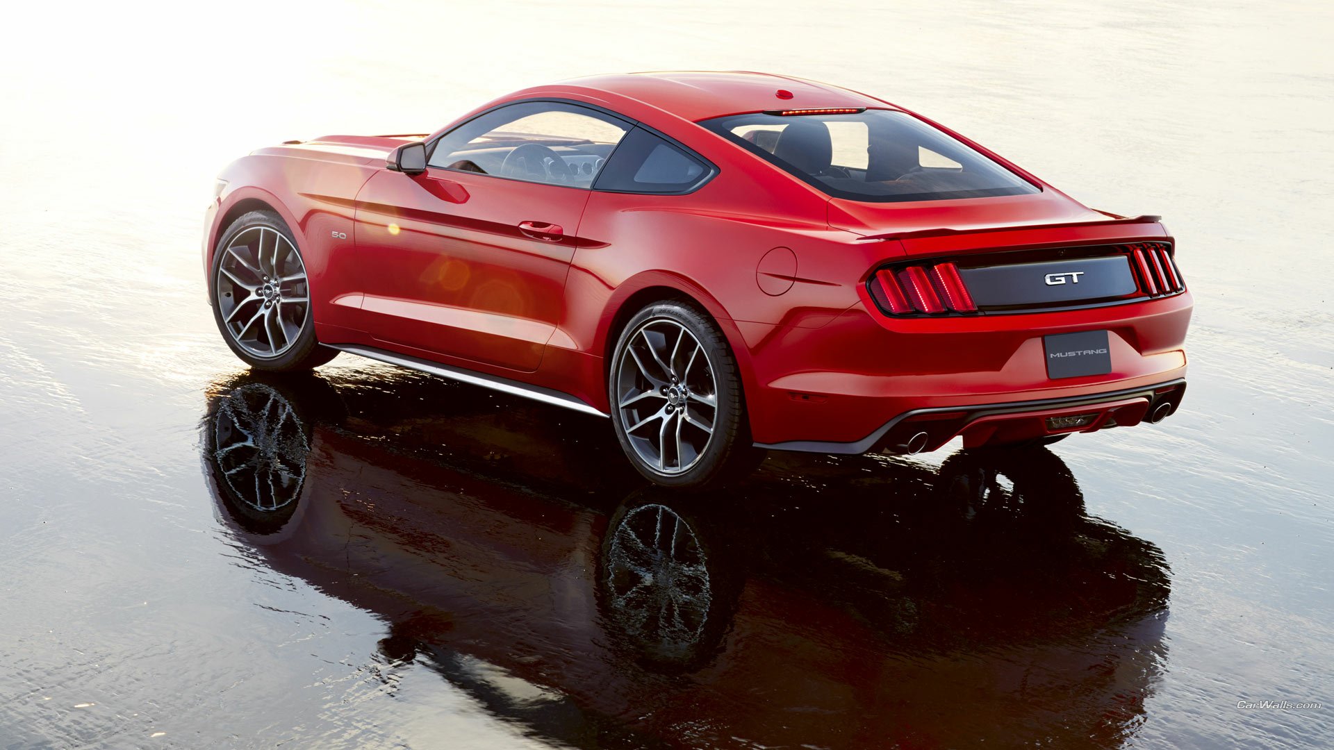 A stunning HD wallpaper featuring a 2015 Ford Mustang GT, showcasing its sleek design and vibrant red color against a reflective surface.