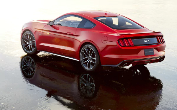 A stunning HD wallpaper featuring a 2015 Ford Mustang GT, showcasing its sleek design and vibrant red color against a reflective surface.