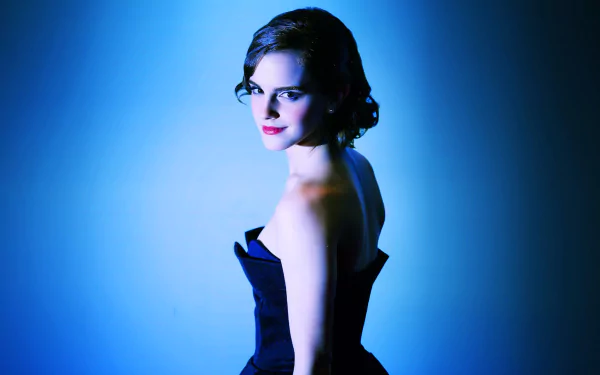 HD desktop wallpaper featuring actress Emma Watson in a dark strapless dress, presenting a vintage glamour look against a moody blue background.