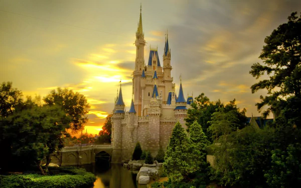 HD wallpaper of Disney World's iconic castle at sunset, surrounded by lush greenery and a serene moat.