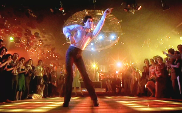 HD desktop wallpaper of a disco dancer in a white suit striking a dramatic pose beneath a mirrored ball — iconic Saturday Night Fever scene featuring Tony Manero.
