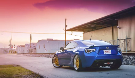 A striking Subaru BRZ parked on a road, showcasing its sleek design and vibrant blue color against a picturesque sunset background. Perfect HD desktop wallpaper for car enthusiasts.