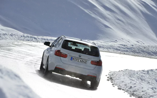 White 2013 BMW 320d driving on a snow-covered mountain road, rear view, high-definition PC desktop wallpaper/background.