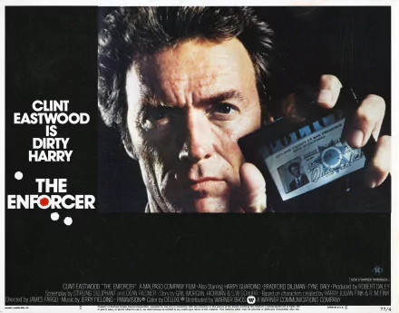 HD desktop wallpaper featuring Clint Eastwood as Harry Callahan from the 1976 movie The Enforcer, holding a police badge close to the camera.
