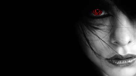 A striking HD desktop wallpaper featuring a dark, artistic image of a person with a vivid red eye set against a black background.