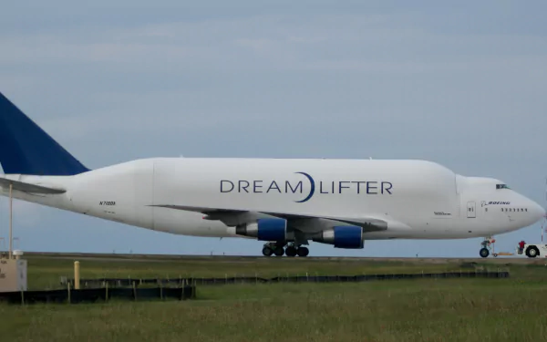 Side view of a Boeing 747 Dreamlifter cargo airplane (vehicle) on the runway with blue tail, white fuselage — HD PC desktop wallpaper background.