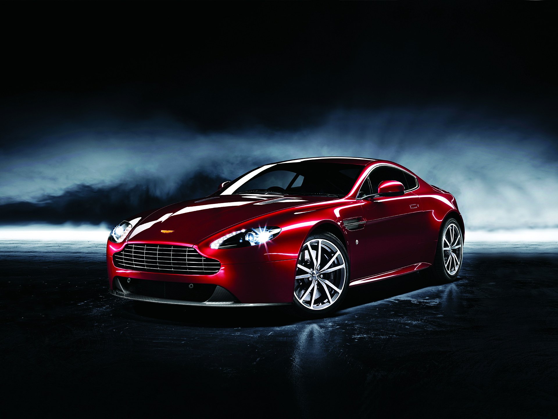 Aston Martin Dragon 88 sports car in glossy red showcased on a dark, reflective surface, captured as a high-definition PC desktop wallpaper and background.