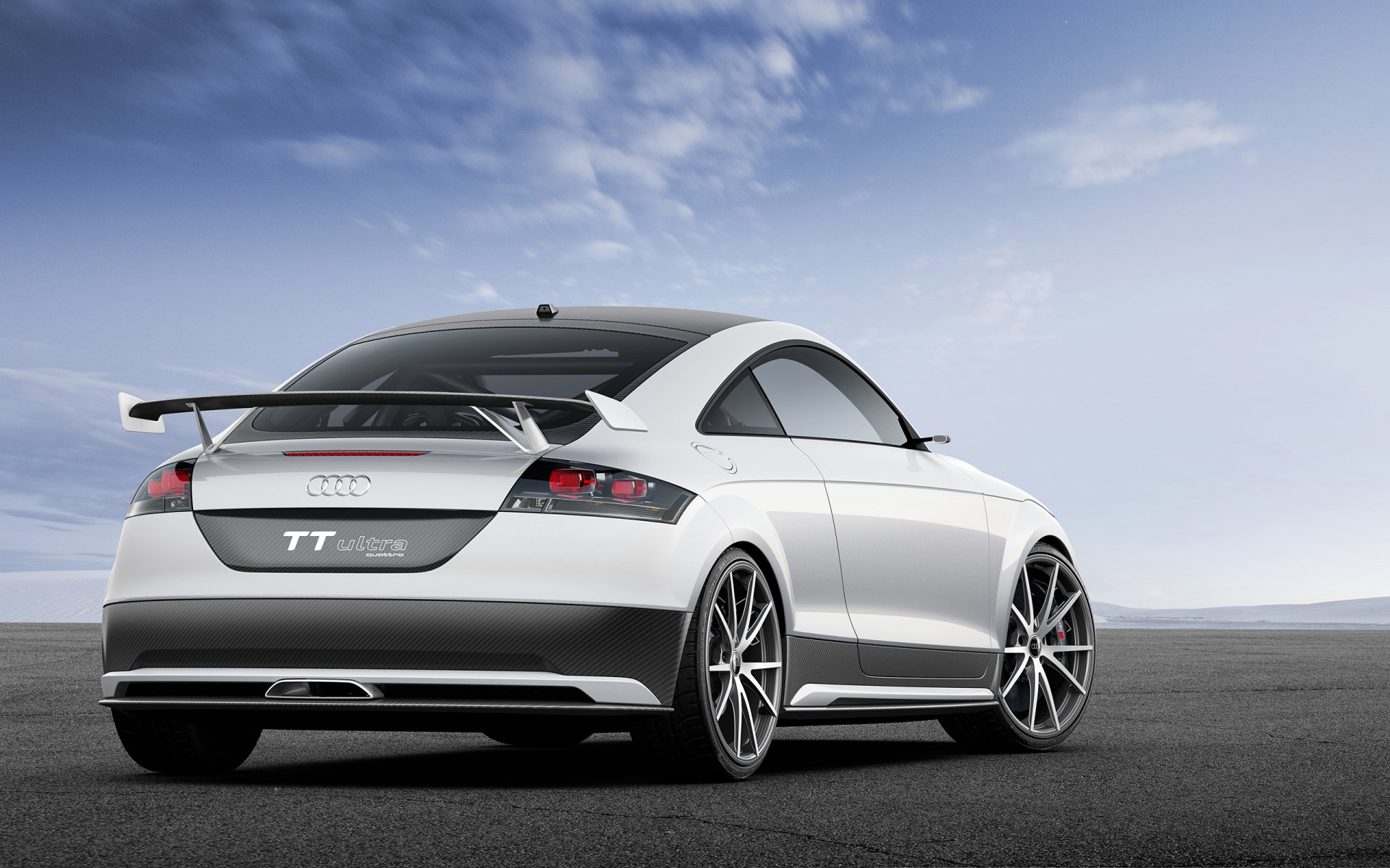 White Audi sports coupe vehicle seen from rear on open asphalt under dramatic sky — 2K Quad HD PC desktop wallpaper/background.