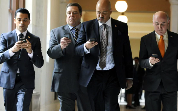 HD desktop wallpaper of characters from Alpha House walking in a corridor, focused on their smartphones.