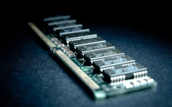 A close-up of a computer memory module, showcasing intricate circuitry and components, set against a dark background, representing technology and memory.