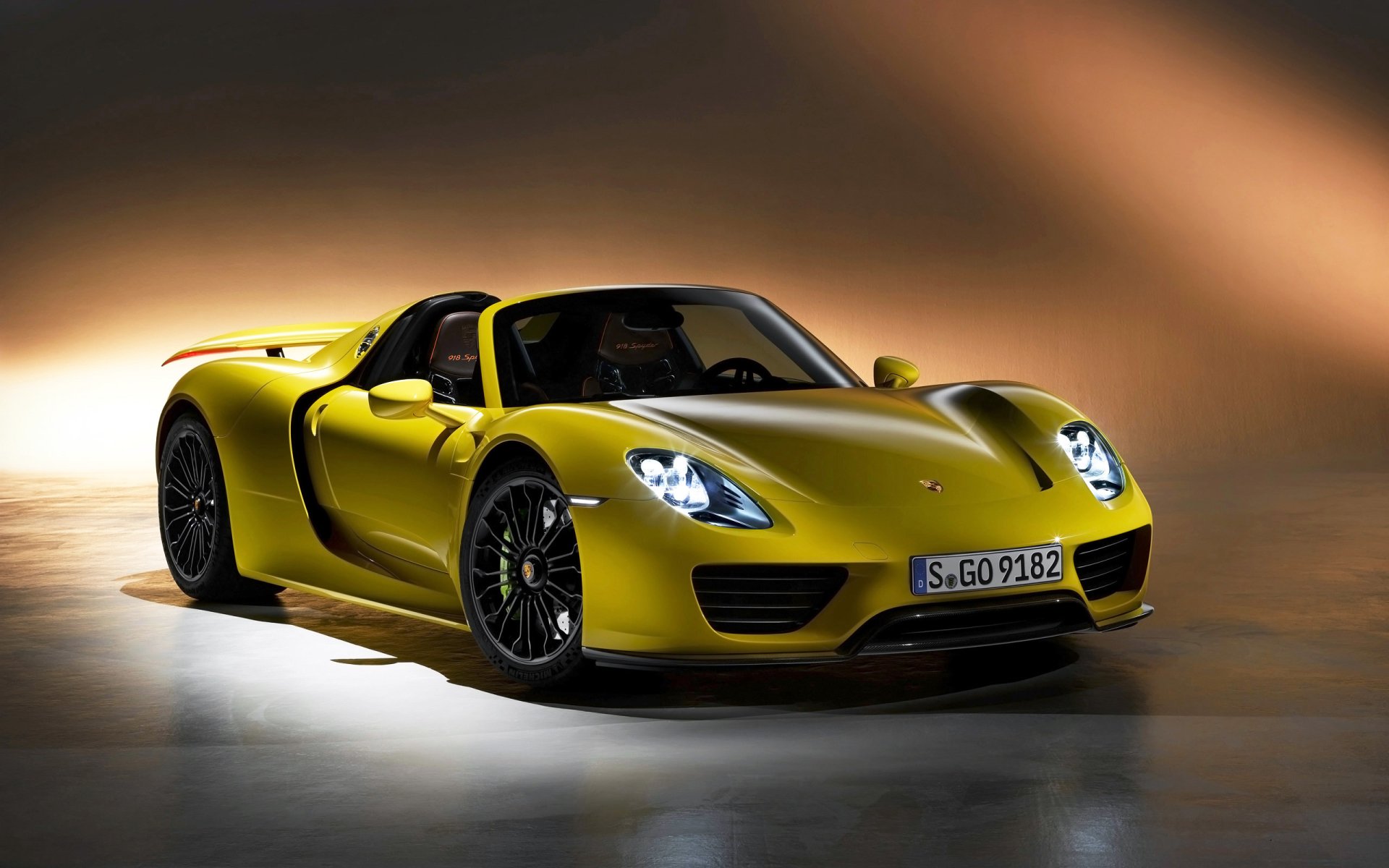 Yellow Porsche 918 Spyder sports car showcased with sleek design and dynamic lighting, set as an HD PC desktop wallpaper and background.